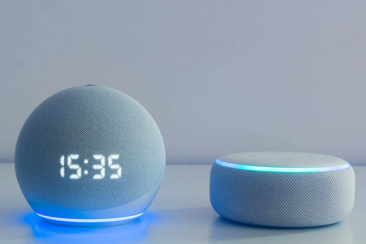 Ein Alexa Echo Dot 4 mit Uhr und ein Echo Dot 3. Beide in weiß
