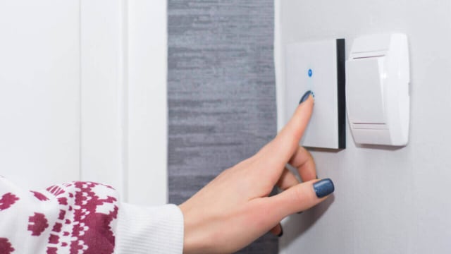 smarter Alexa Lichtschalter wird von Frauenhand bedient